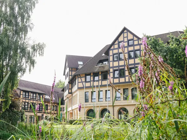 Fachwerkfassade des Hotels hinter blühenden Gräsern