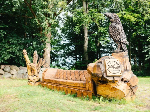 Holzskulptur eines Raben im Park